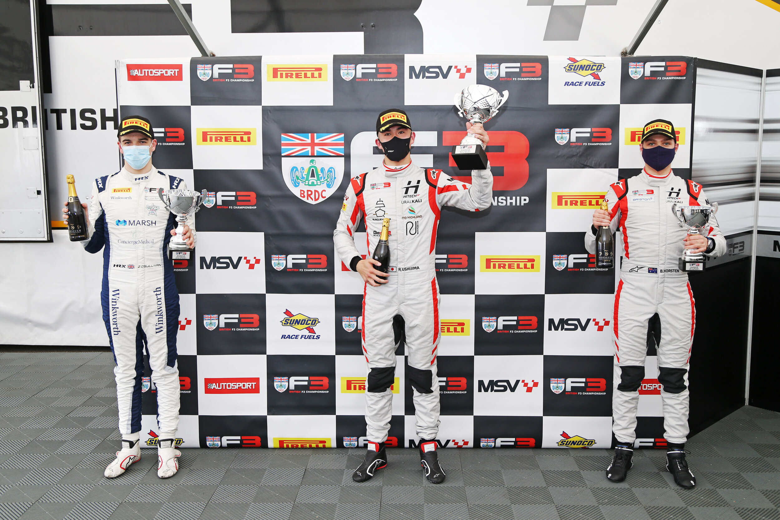 Reece Ushijima, Zak O’Sullivan, and Bart Horsten celebrate on the Race 1 podium at Silverstone. (Jakob Ebrey)