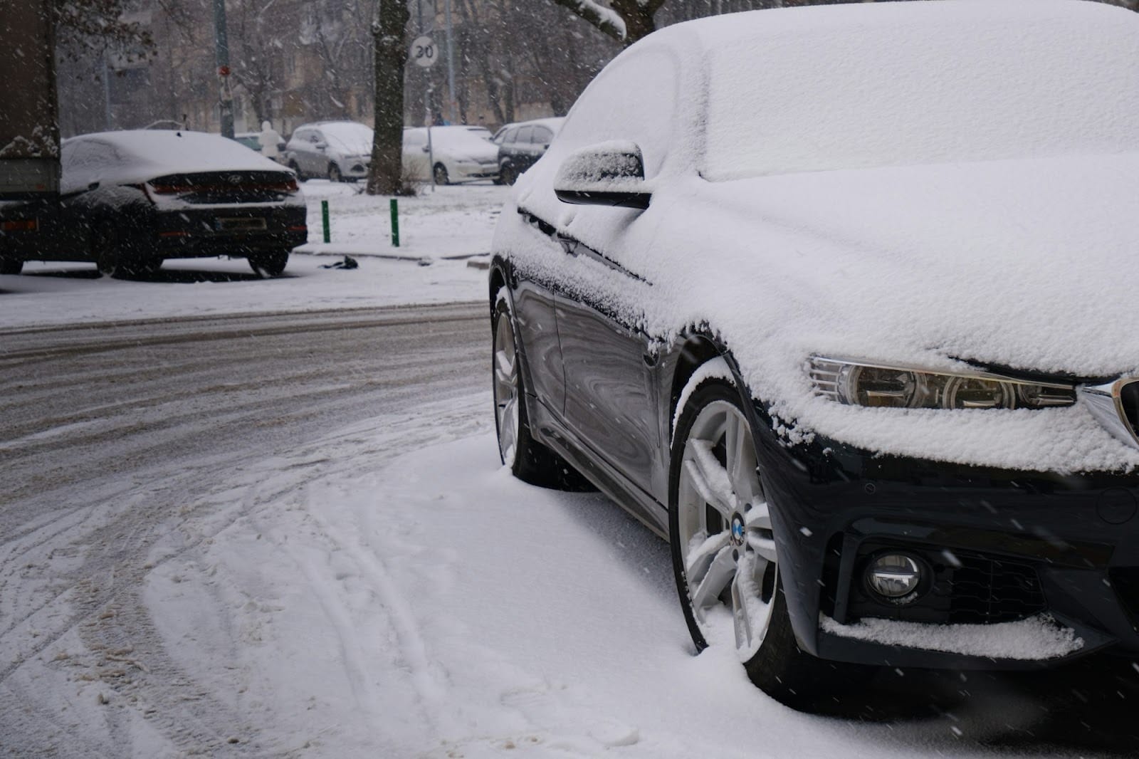 a car covered in snow on a snowy street