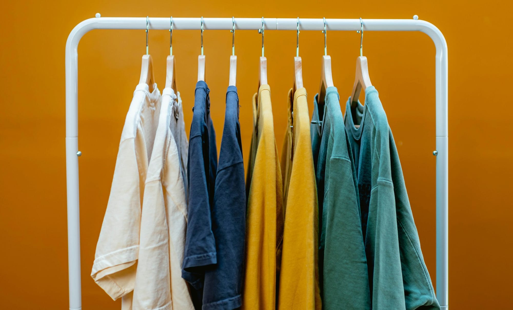 A rack that has a bunch of clothes hanging on it