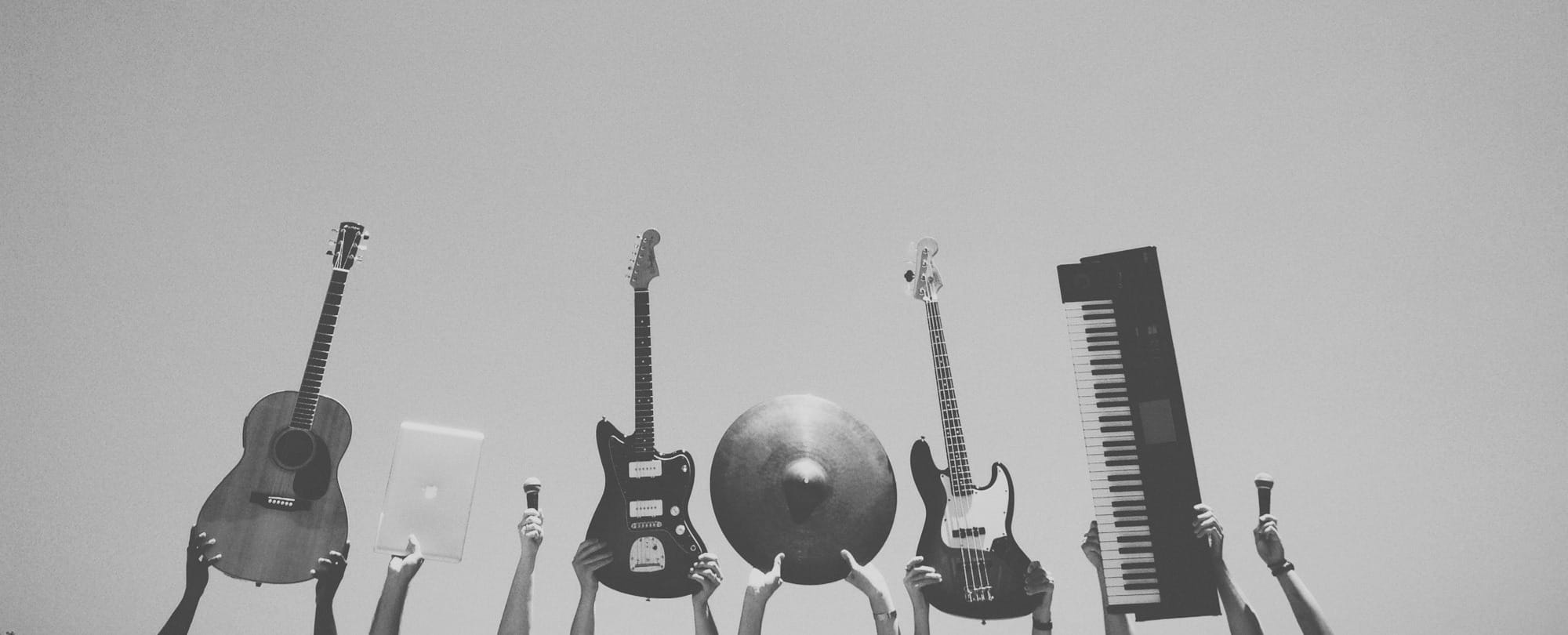 grayscale photo of people holding assorted music instruments