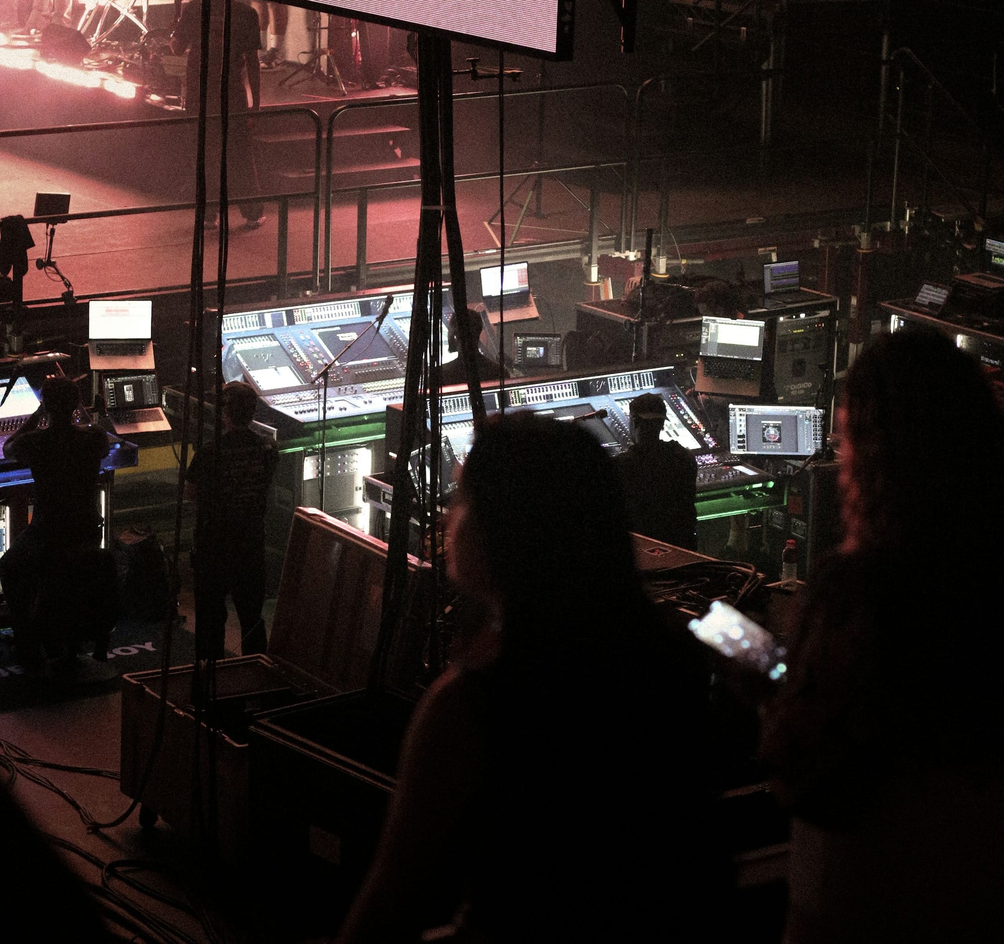 People working at a control desk with screens.