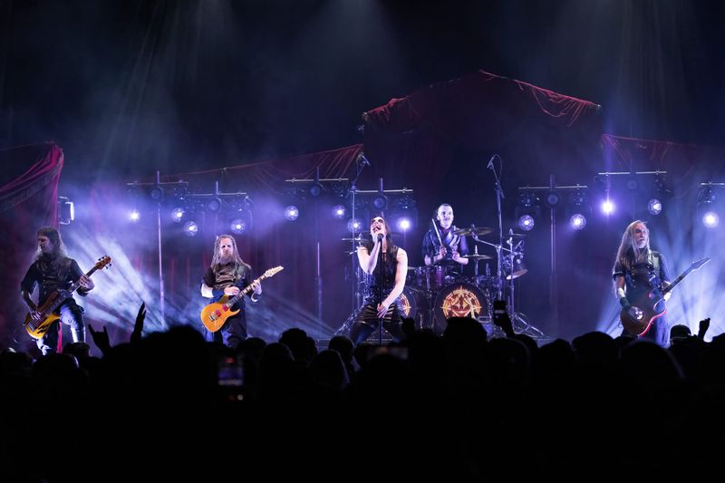 Avatar performing on stage with purple lighting