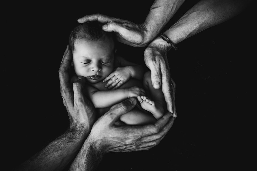 An unaborted baby safe between parent's hands.