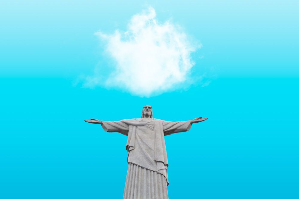 Statue of Jesus with arms open against a blue sky in Rio De Janeiro, Brazil.