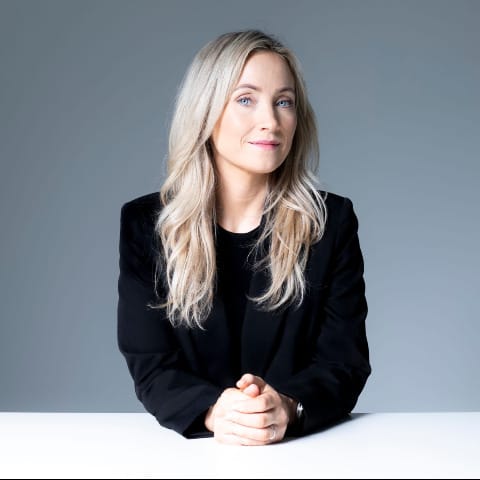 Author Eva Björg Ægisdóttir with hands clasped and looking secretive. 