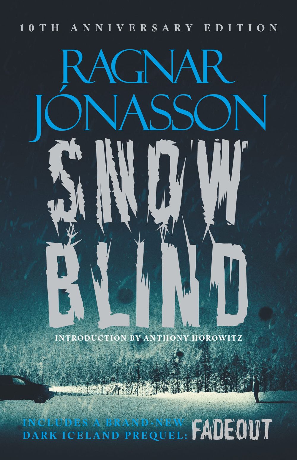 Cover of "Snowblind" by Ragnar Jónasson. 10th Anniversary Edition. Author's name in blue font at top. Book title in jagged grey font. Forest under huge black sky with snow in background. 