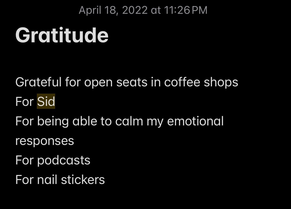 iPhone note that reads "Gratitude" at the top and a list that says, "Grateful for open seats in coffee shops, For Sid, For being able to calm my emotional responses, For podcasts, For nail stickers"