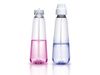 Two unlabelled, transparent plastic aerosol bottles sit side by side, containing pink and blue liquid, respectively. The…