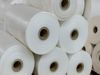 A close-up of thick rolls of polyethylene stacked on top of each other in a warehouse.