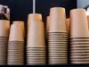 Five rows of stacked paper cups. The stacks are not even, allowing taller stacks to be seen behind the stacks in the…