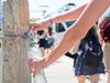 A person filling up a plastic bottle at a public water tap