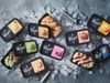 A large pile of ice cubes has been arranged on a metal surface. On top of it are two ice cream scoopers in amongst various…