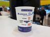 A picture of a reusable cup on a table, the cup has logos of the participating companies on it.