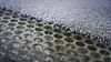 A picture of plastic granules about to be sorted on a perforated screen