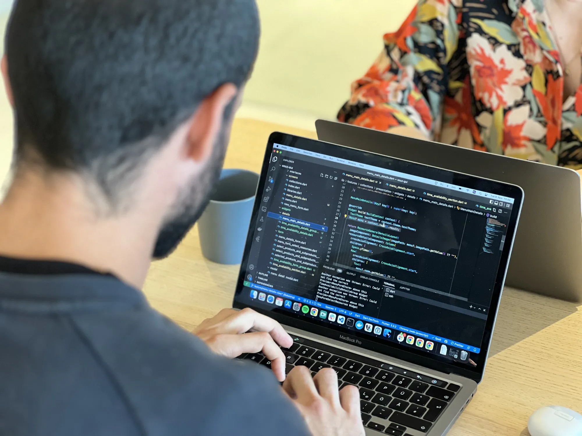 Software Developer sitzt an seinem Macbook und arbeitet