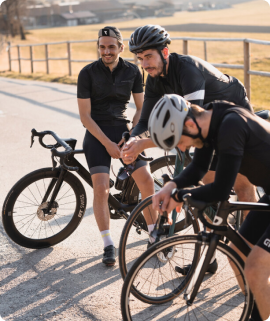 Drei Männer mit Rennrädern machen eine Pause vom Fahrradfahren.png