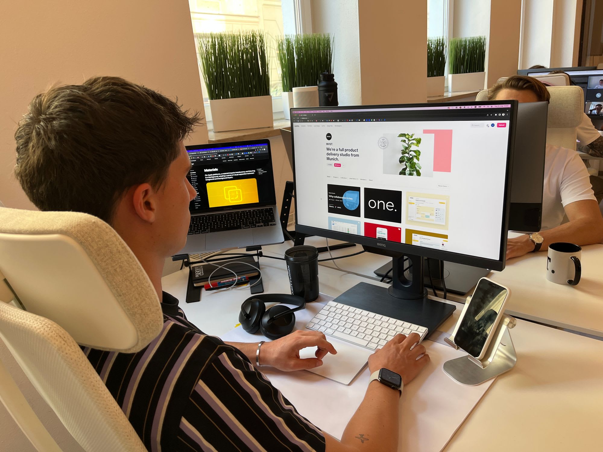 Designer sitzt an seinem Schreibtisch in Büro und sieht sich website designs an