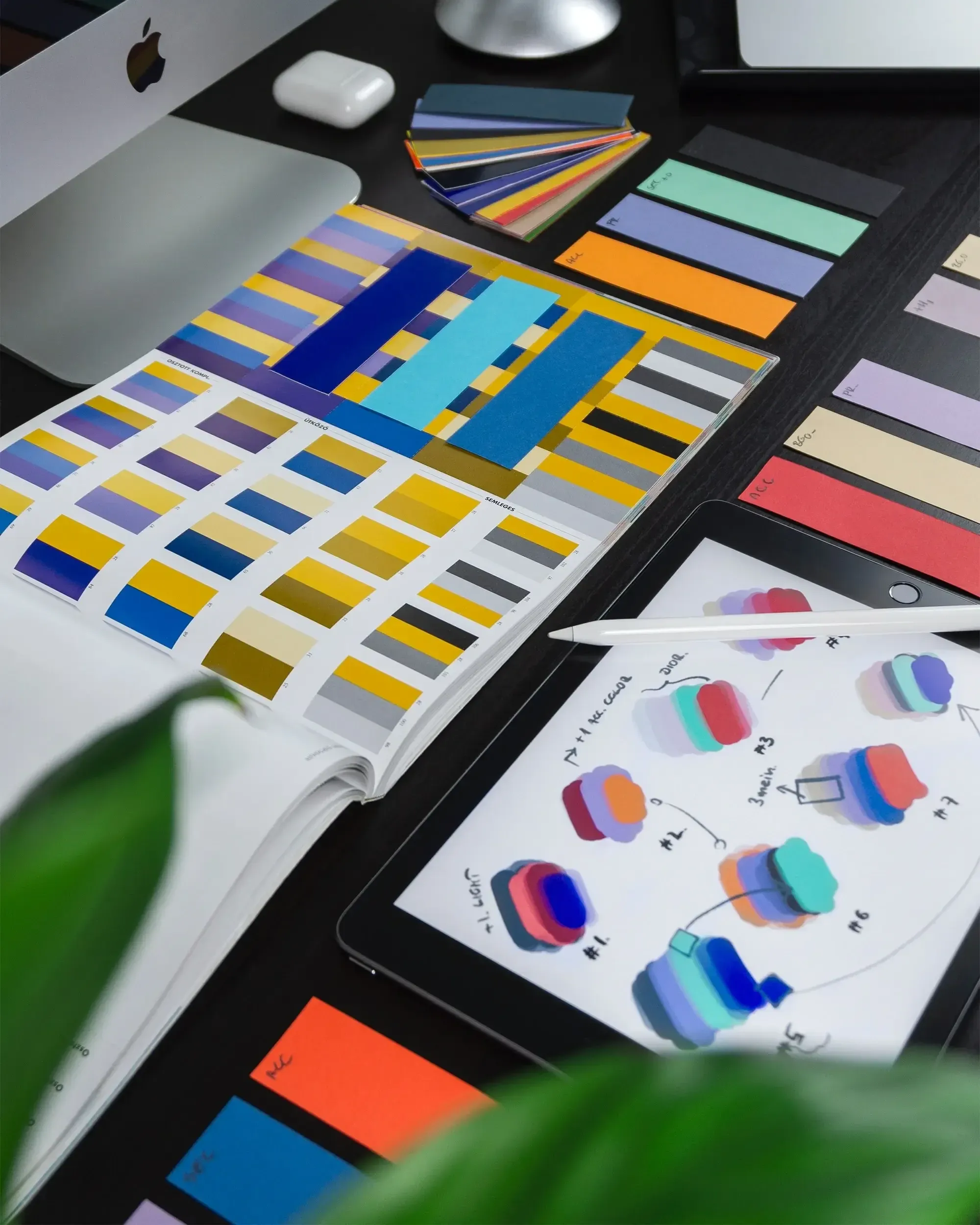 Different color palettes in front of a mac and tablet showing more color combinations.