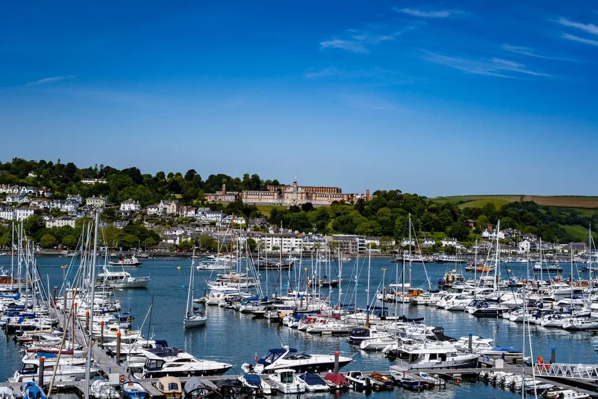 Motorboats and yachts moored on pontoons in a Devon estuary marina, the vessels insurers ask owners to log.