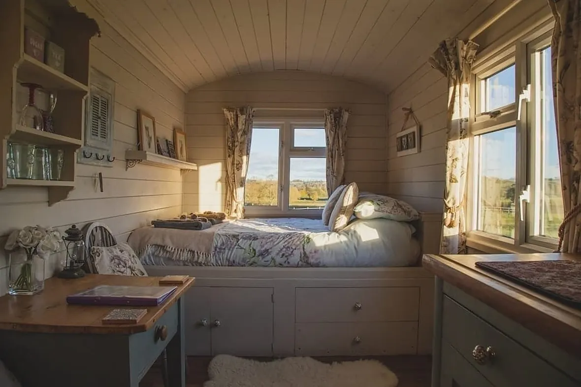 A UK caravan interior, annual habitation servicing checks gas, electrics, damp and bodywork, recorded in the service log.