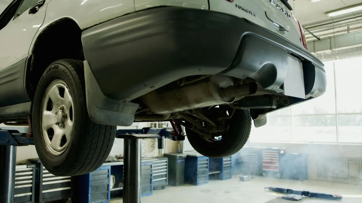 A car raised on a workshop lift with its underside exposed, the kind of service visit that fills in a full service history.