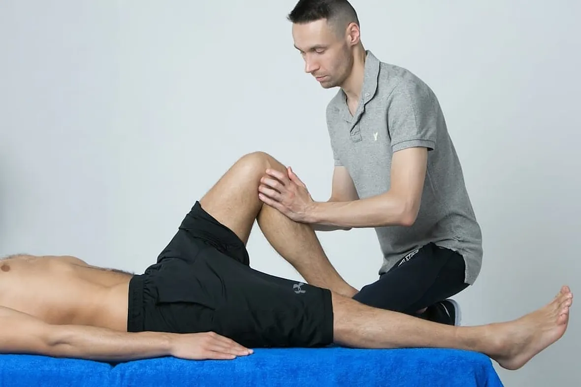 A UK physiotherapist working with a patient, HCPC record-keeping standards apply to 15 allied health professions.
