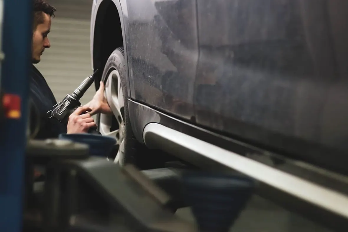 A UK mechanic checking a car's service book, partial service history typically costs 5-15% off a used car's value.