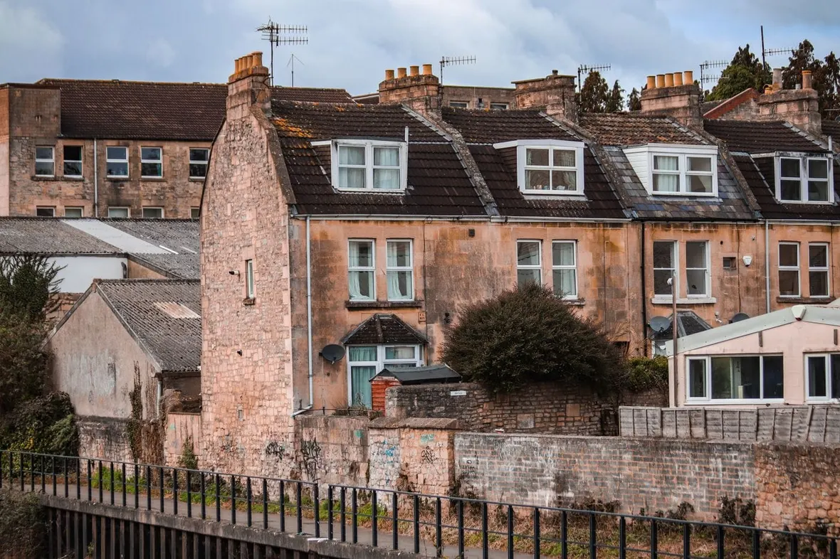Rear elevations of stone terraced houses showing roofs, walls and extensions, a condition report records a property's fabric.