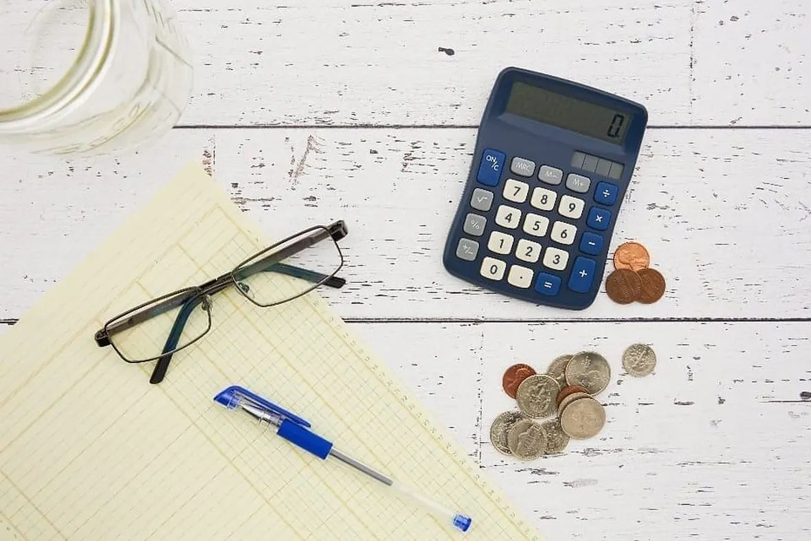 Coins and a calculator, pricing up a UK property logbook