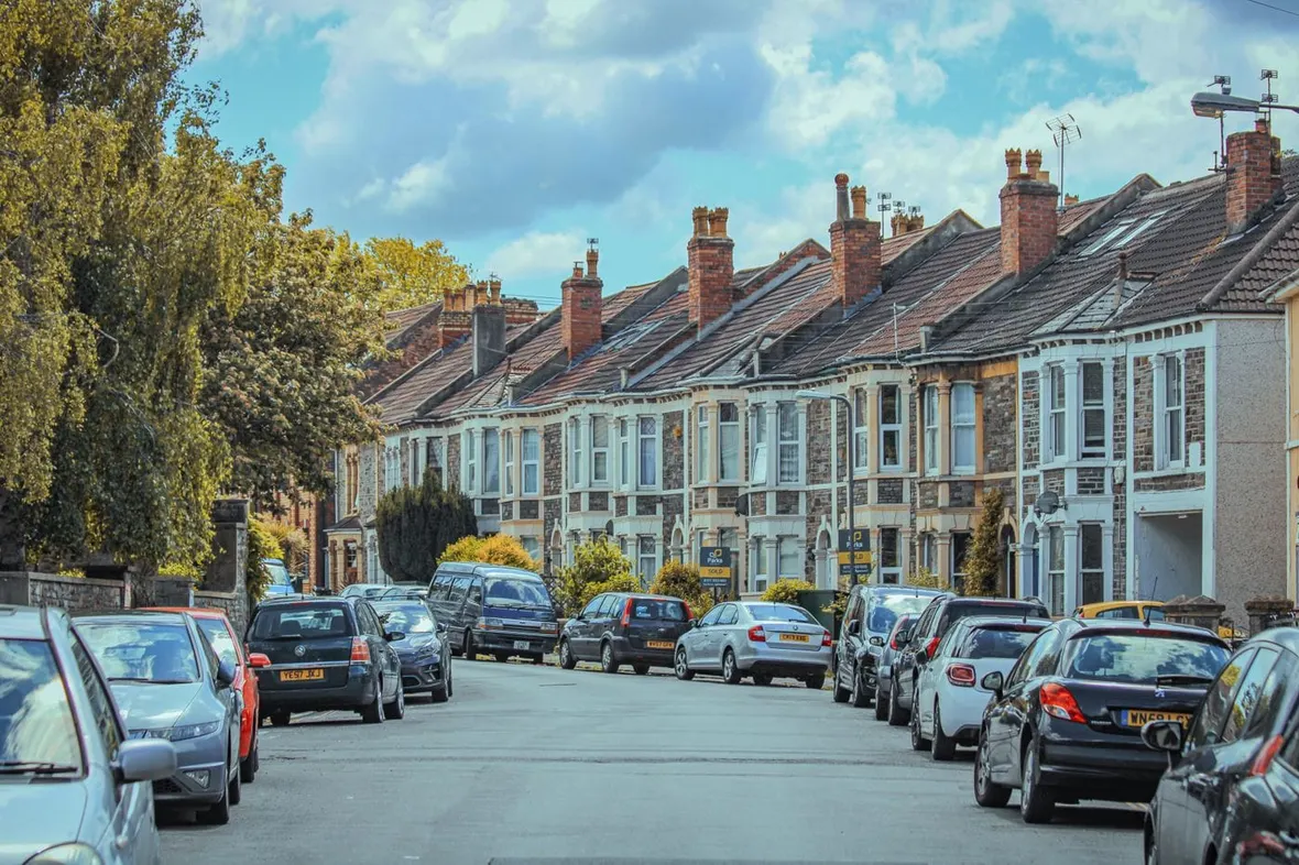 A UK residential street lined with parked used cars, an HPI check reveals finance, write-off and theft history before you buy.