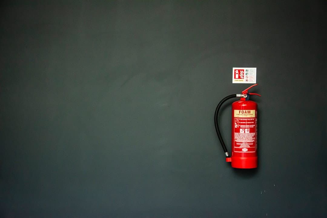 A row of UK fire extinguishers — BS 5306 sets annual servicing, extended service, and replacement intervals.