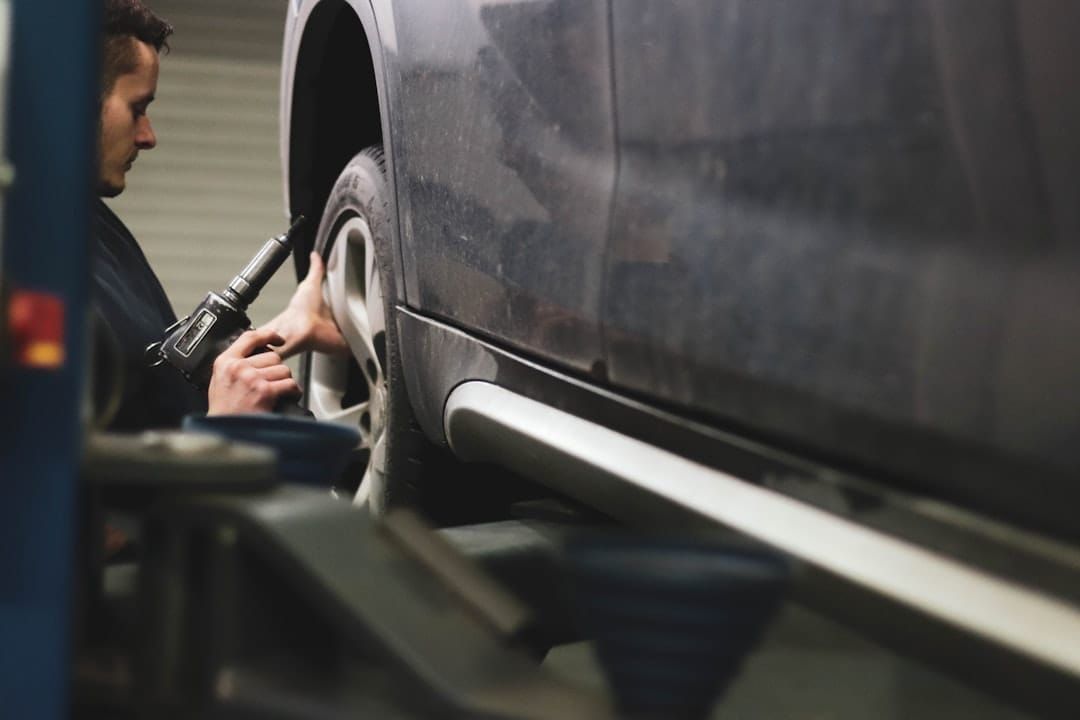 A UK mechanic checking a car's service book — partial service history typically costs 5-15% off a used car's value.