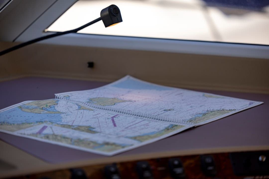 Yacht navigator plotting a course — RYA personal logbooks record sea miles and qualifying passages.