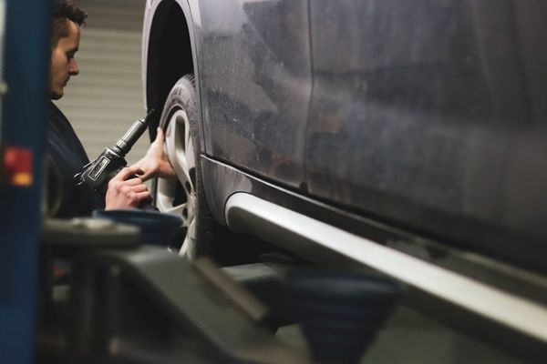 A UK mechanic checking a car's service book — partial service history typically costs 5-15% off a used car's value.