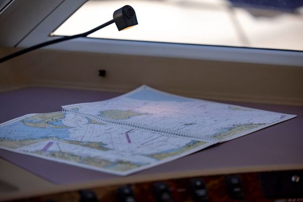 Yacht navigator plotting a course — RYA personal logbooks record sea miles and qualifying passages.