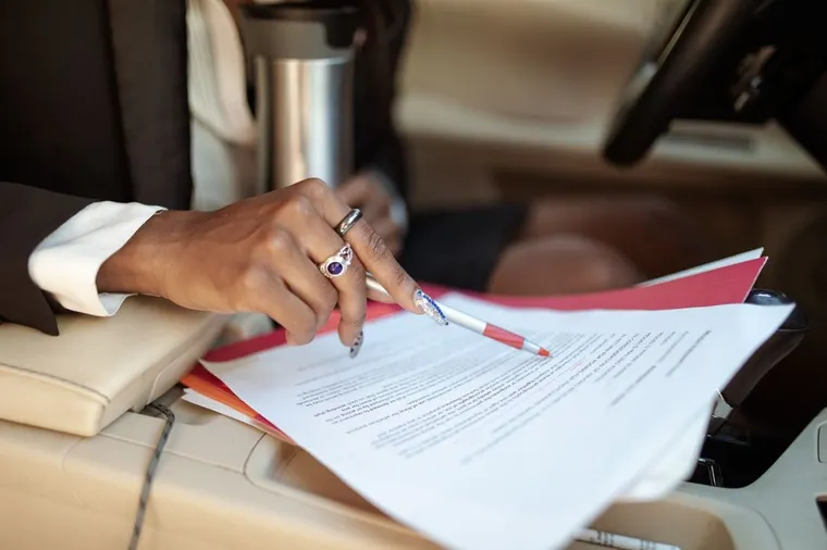 Vehicle paperwork being read inside a car, DVLA lets you check tax, MOT and the last V5C issue date online for free.