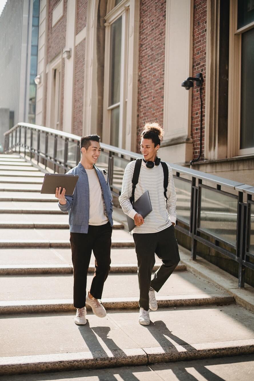 Two male students walking and talking.
