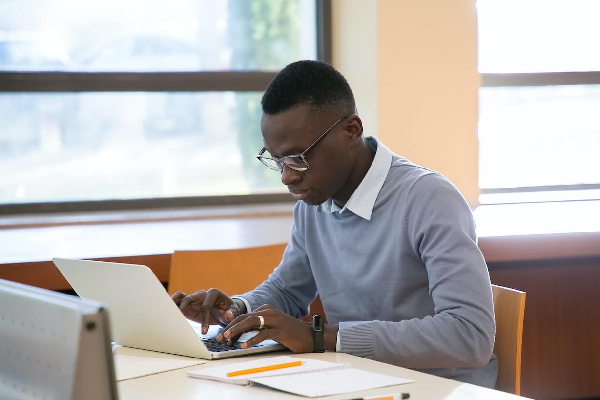 Student studying and typing at computer.