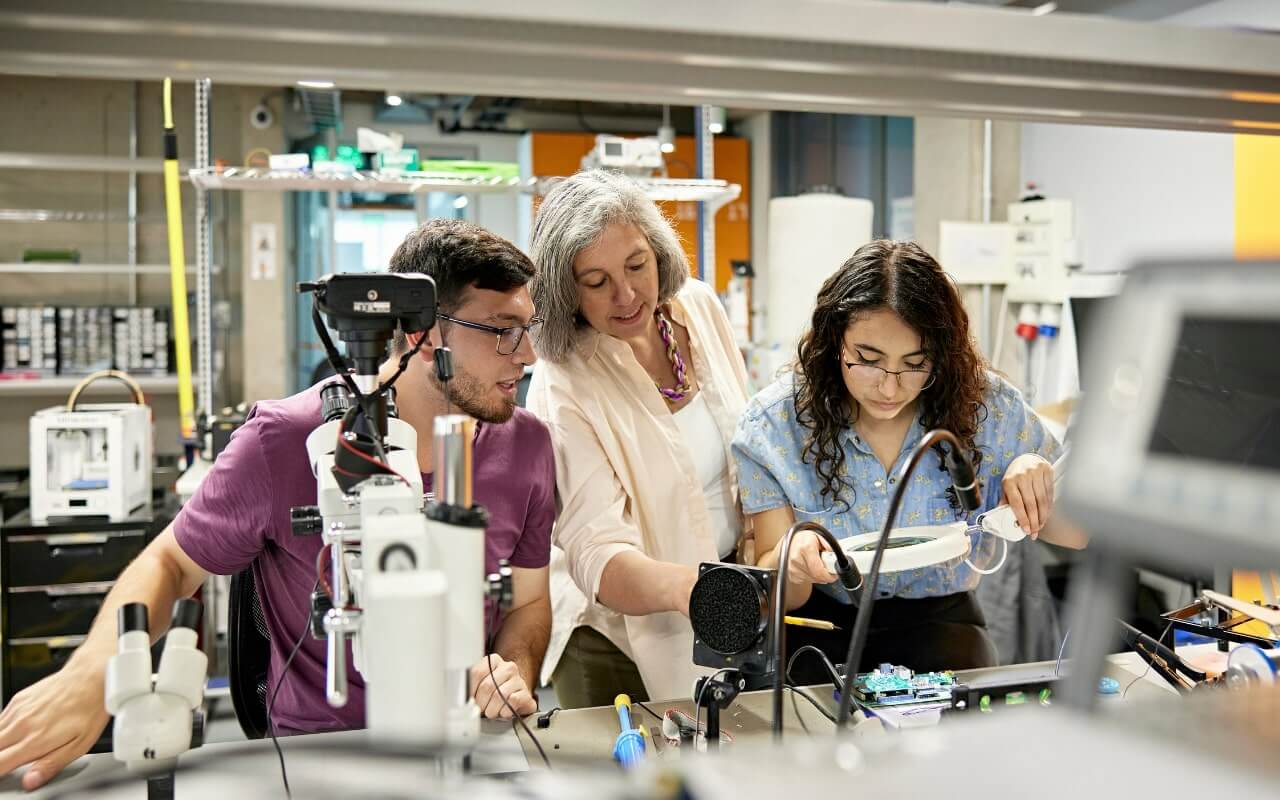 student researchers examine lab equipment