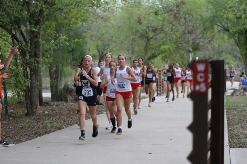 student athletes run through the woods