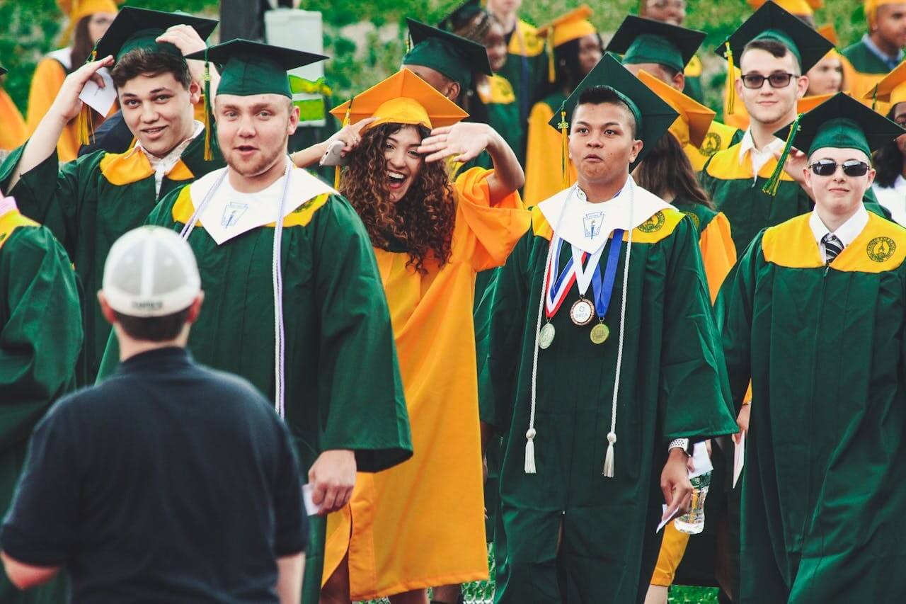 graduating class in green and yellow robes
