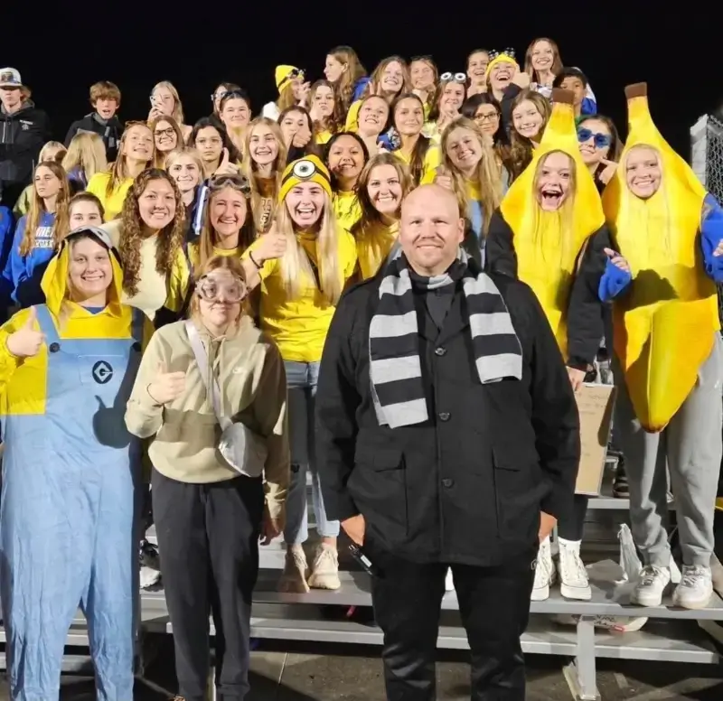 students take a photo dressed as minions with their professors, dressed as gru