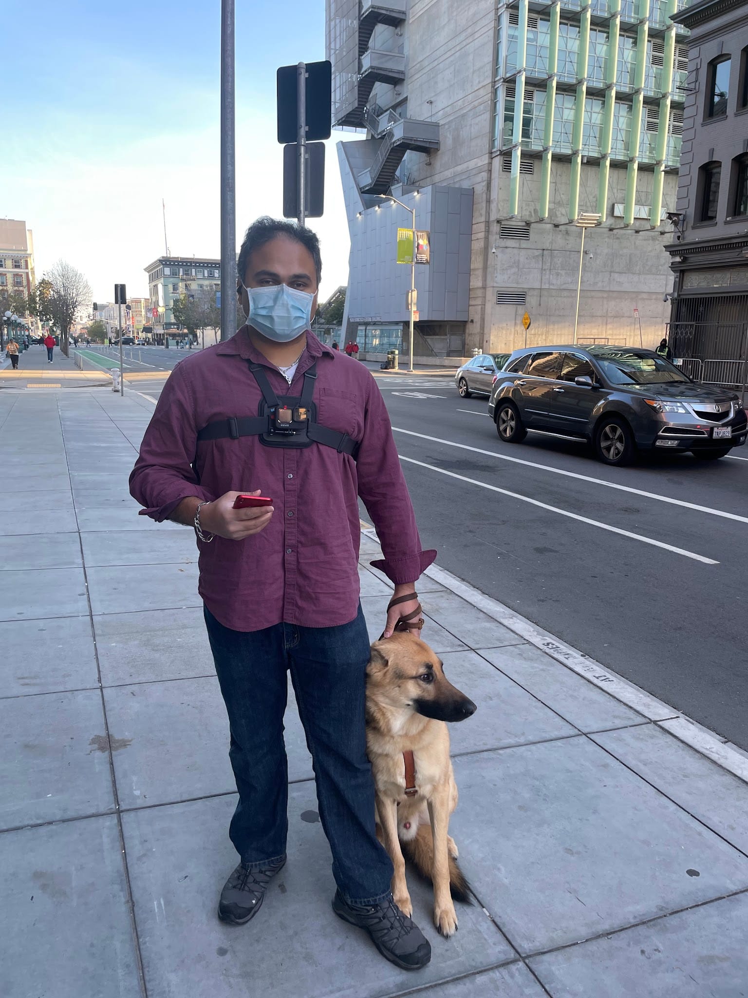 A participant standing on the sidewalk with their guide dog.