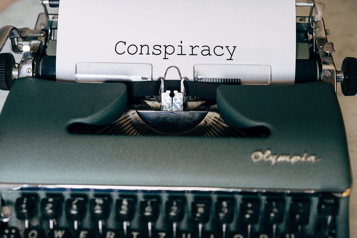 A pretty green typewriter displaying the word "Conspiracy"
