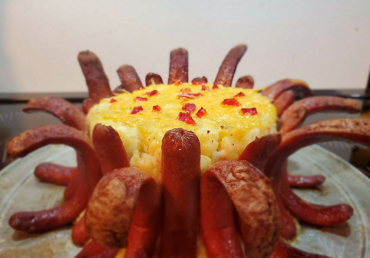 20 singed frankfurter halves flop grotesquely away from a cheesy, pimento-strewn tower of hot potato salad.