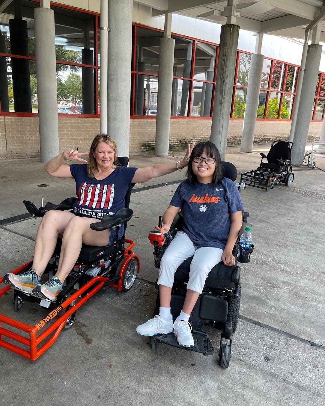 A person and a child in wheelchairs

Description automatically generated