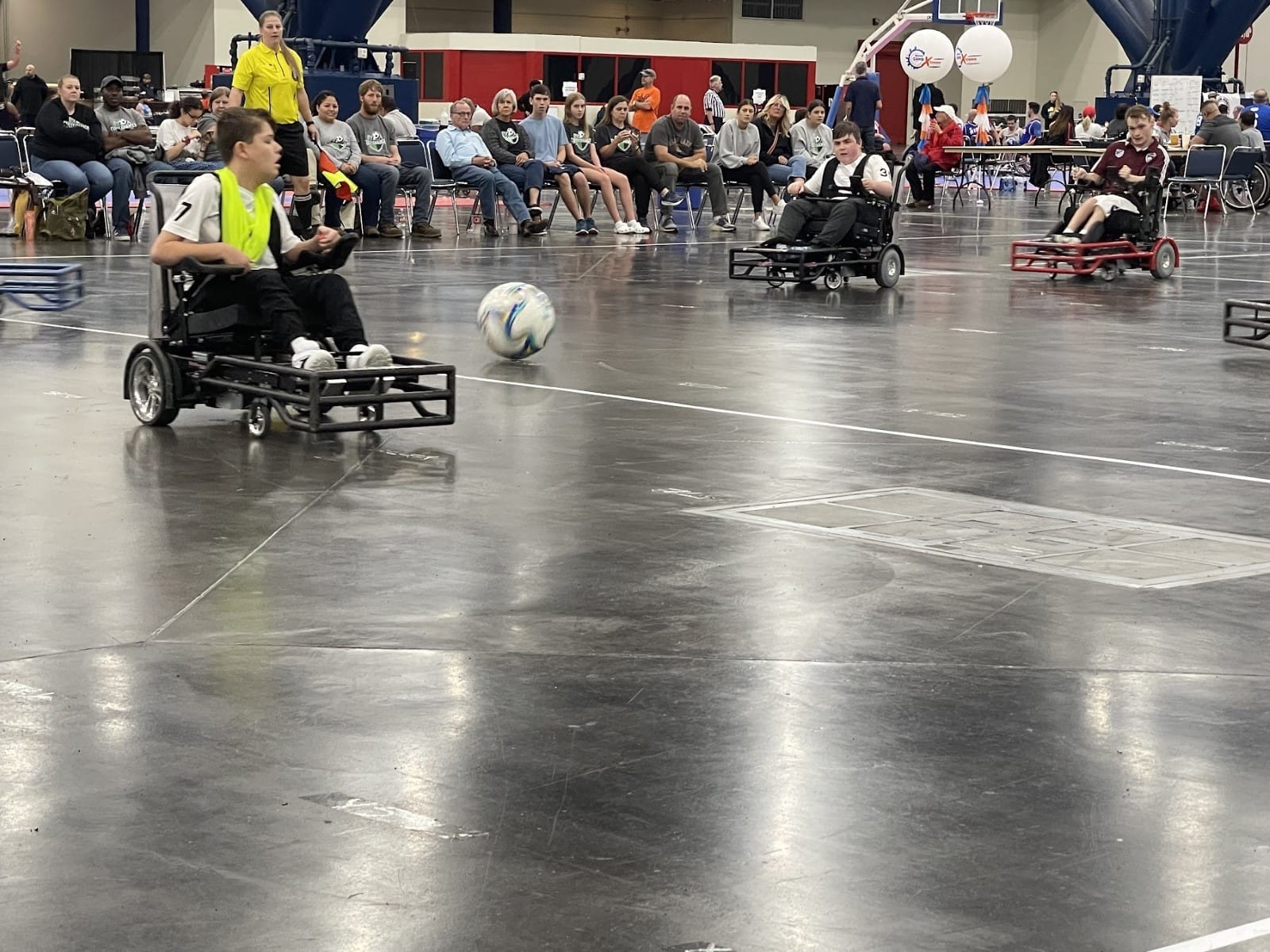 A group of people in wheelchairs playing football

Description automatically generated