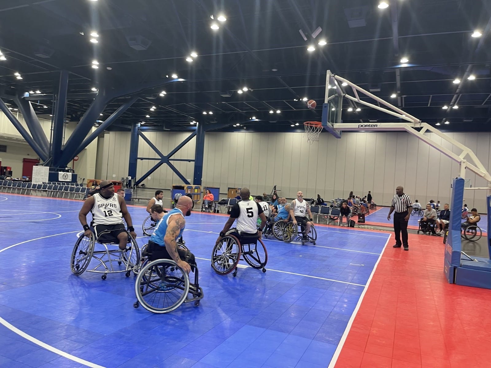 A group of people in wheelchairs on a basketball court

Description automatically generated