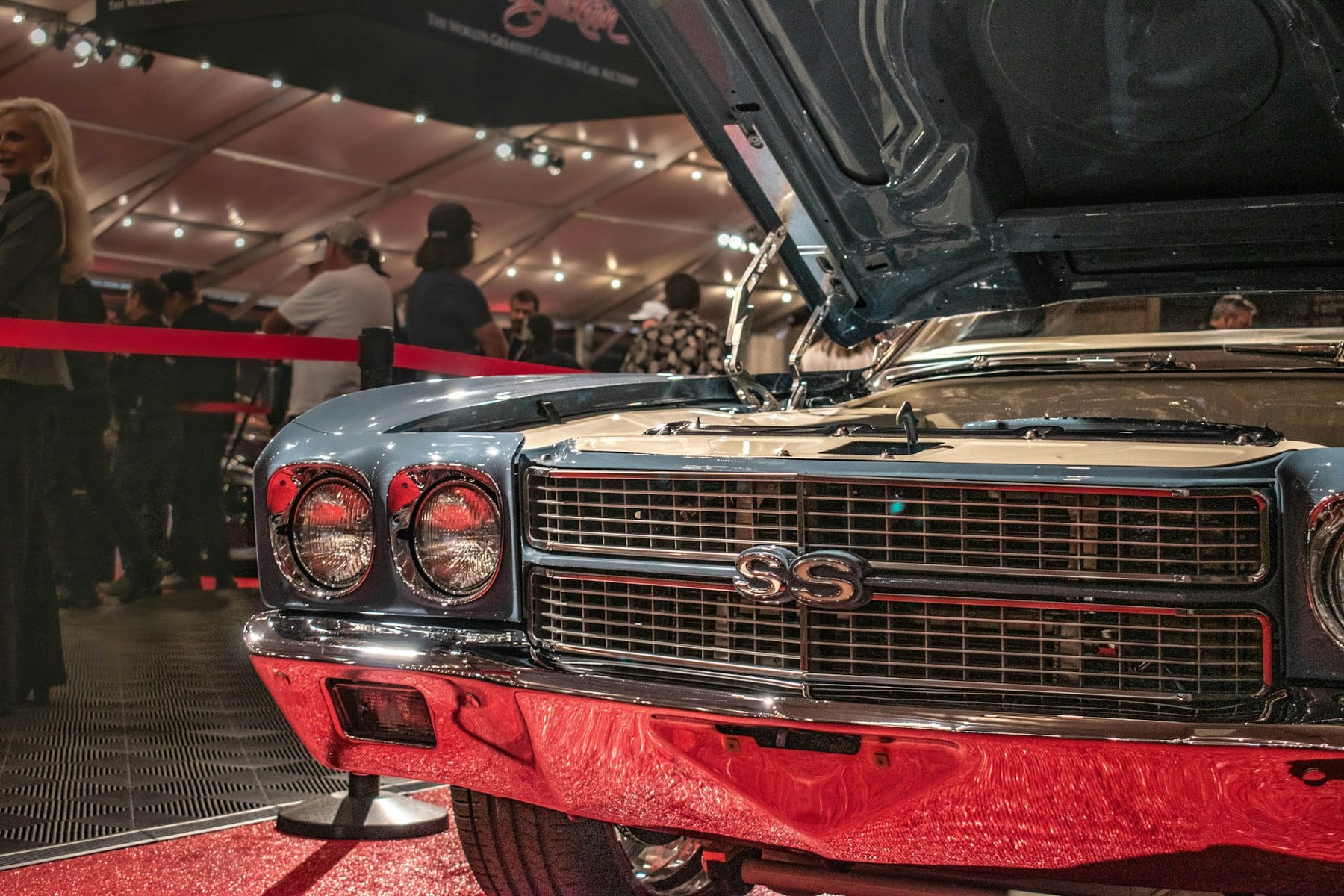 Classic car with the hood raised at a collector car show, engine bay open for inspection