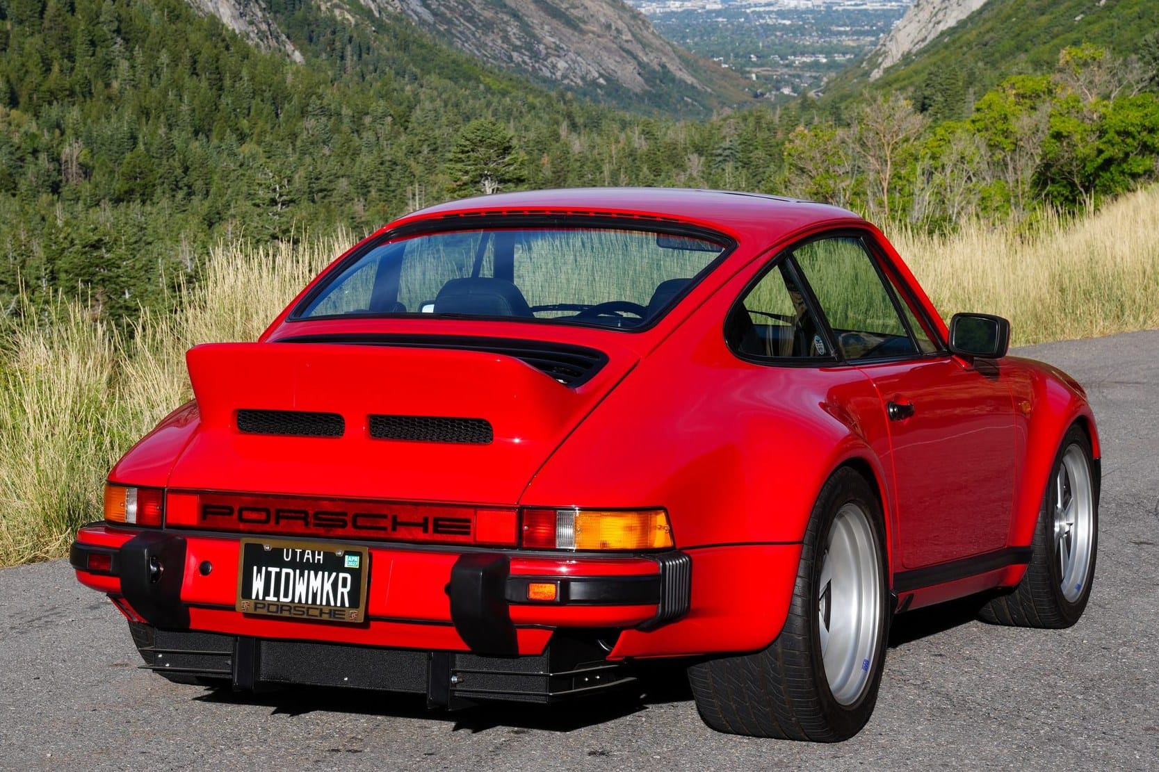 Rear three-quarter view of a red 1983 Porsche 911 Turbo with a ducktail decklid